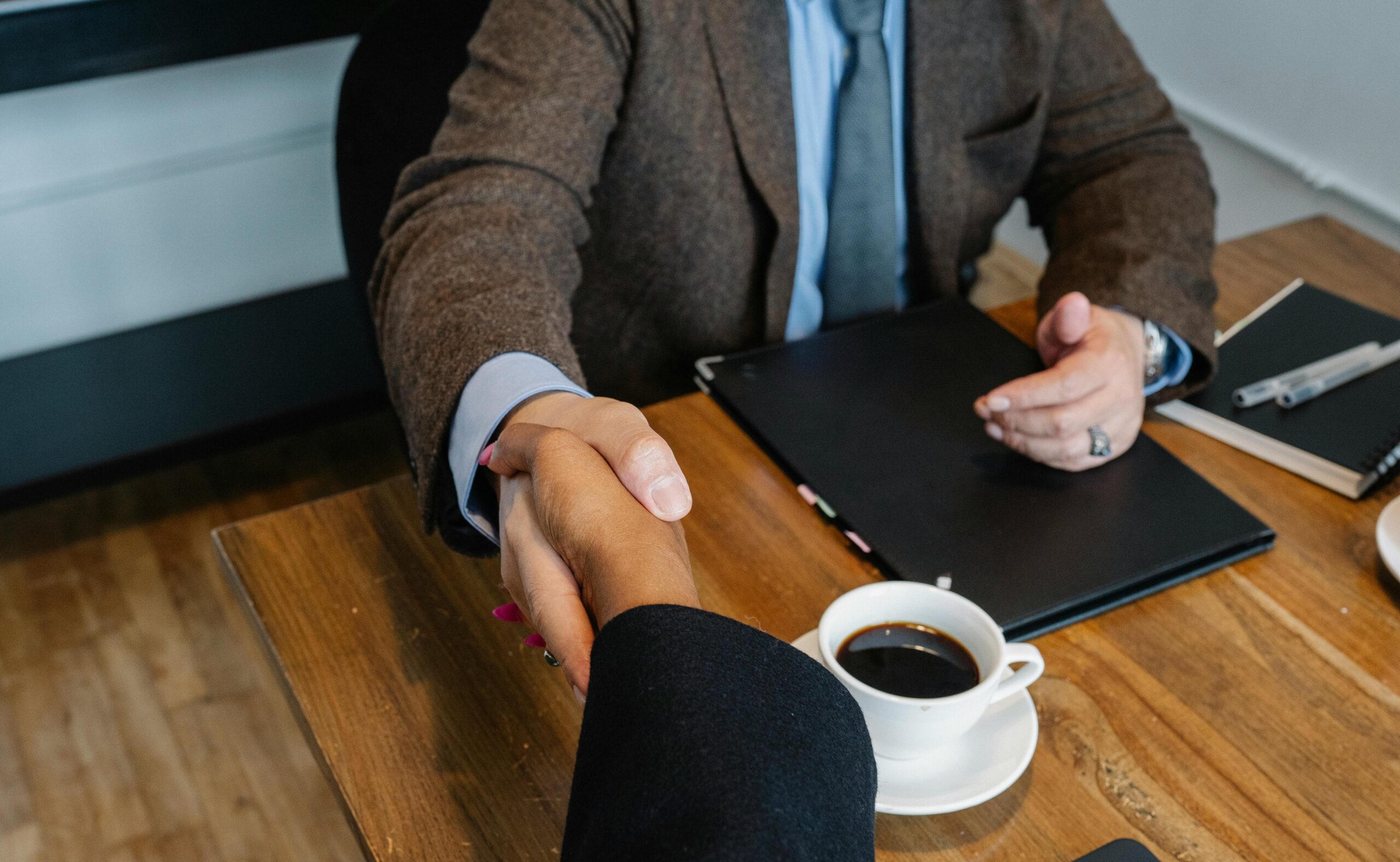 Crop businesspeople making deal during workday